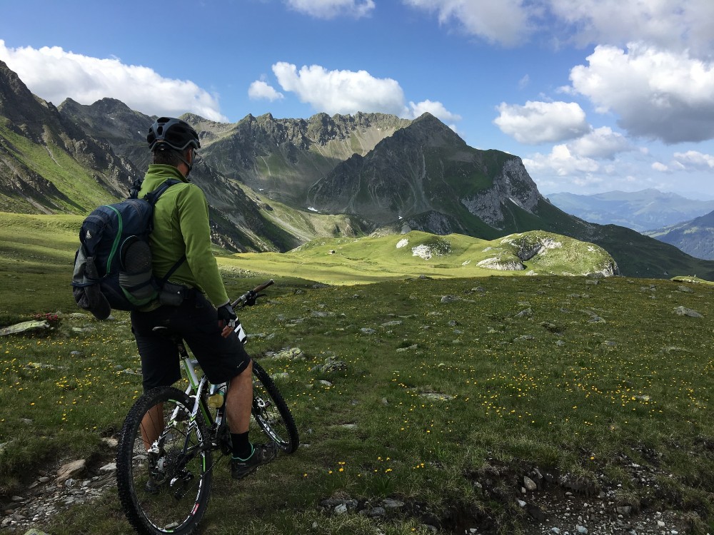 ciclista parado frente a un paisaje de montaña