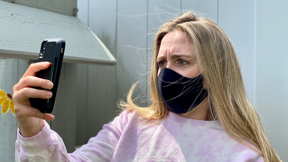 desbloqueando iPhone con mascarilla en el rostro, mujer