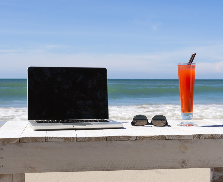 lapto en un escritorio en la playa