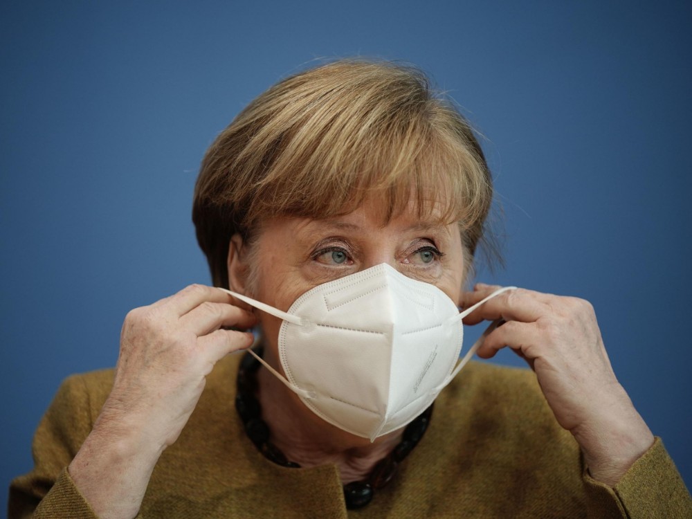 Angela Merkel poniéndose una mascarilla