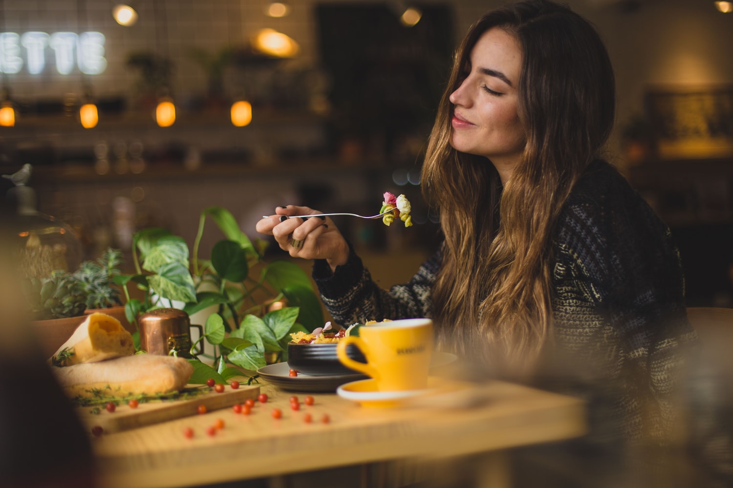 mujer deleitando un plato en restaurantes