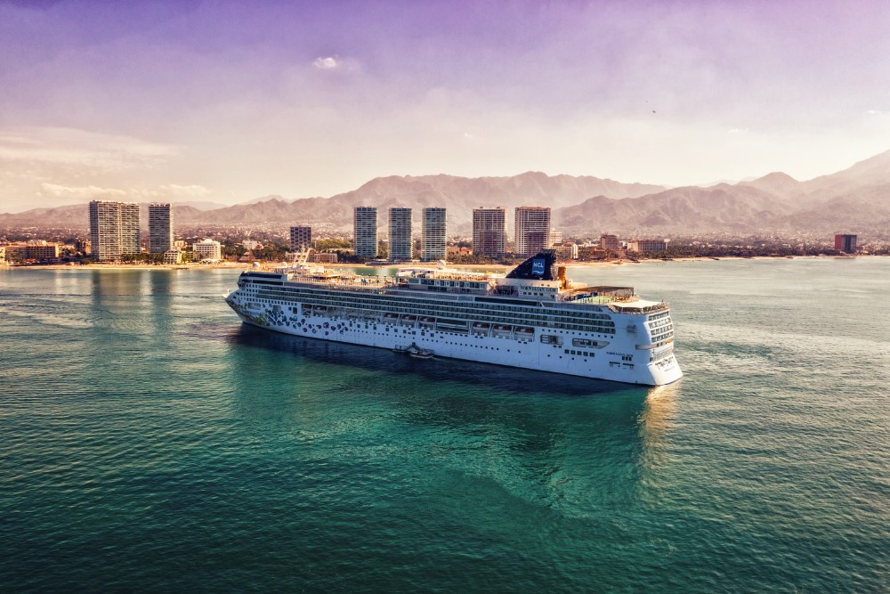 barco de NCL frnte a una ciudad