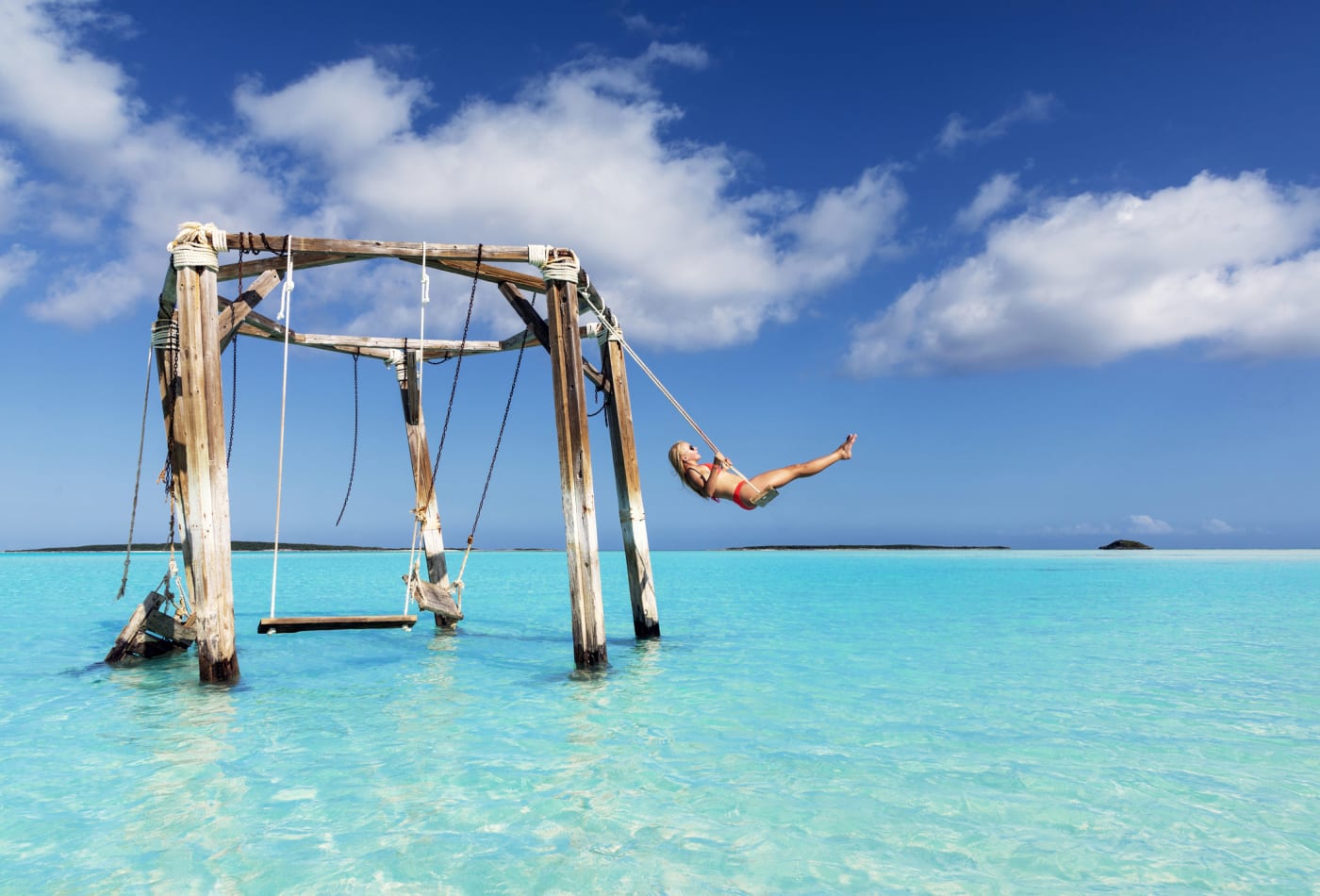 Bahamas, mujer en columpio sobre el agua