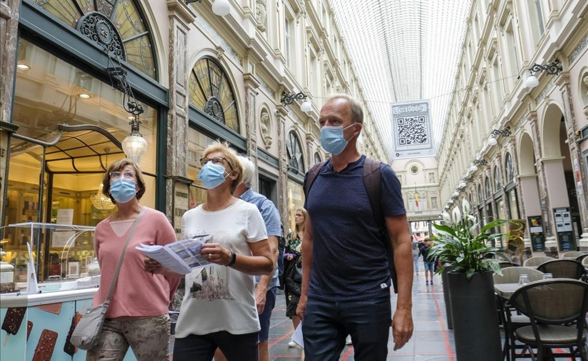 tres personas por una calle de Bruselas