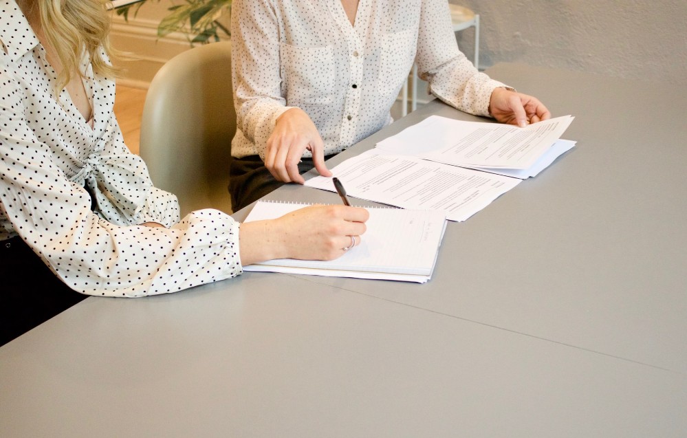 dos mujeres y papeles en una mesa