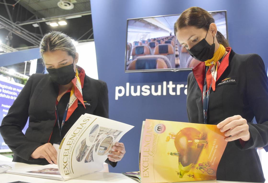 stand Plus Ultra en FITUR, dos azafatas con revista Excelencias