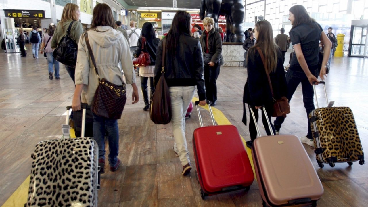 turistas españolas con sus maletas, de espalda