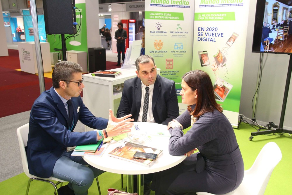 reunión en FITUR, en un stand, dos hombres y una mujer