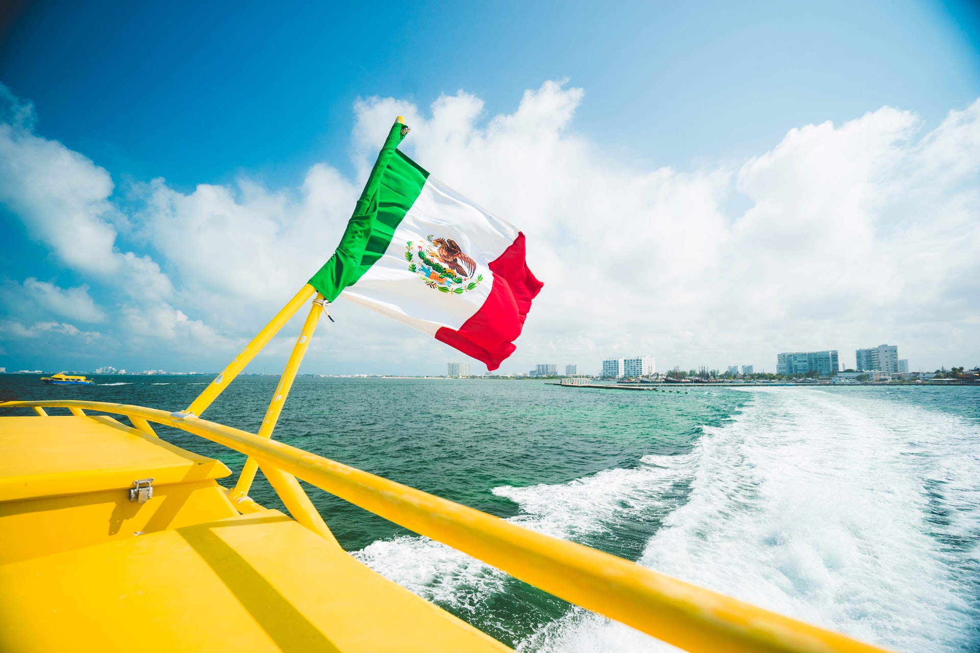 yate con bandera mexicana por la costa de Cancún