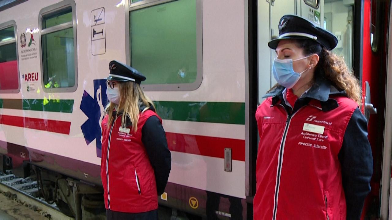 dos mujeres custodian la puerta de un tren en Italia