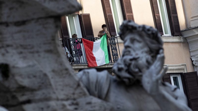 mujer en un balcón con bandera italiana