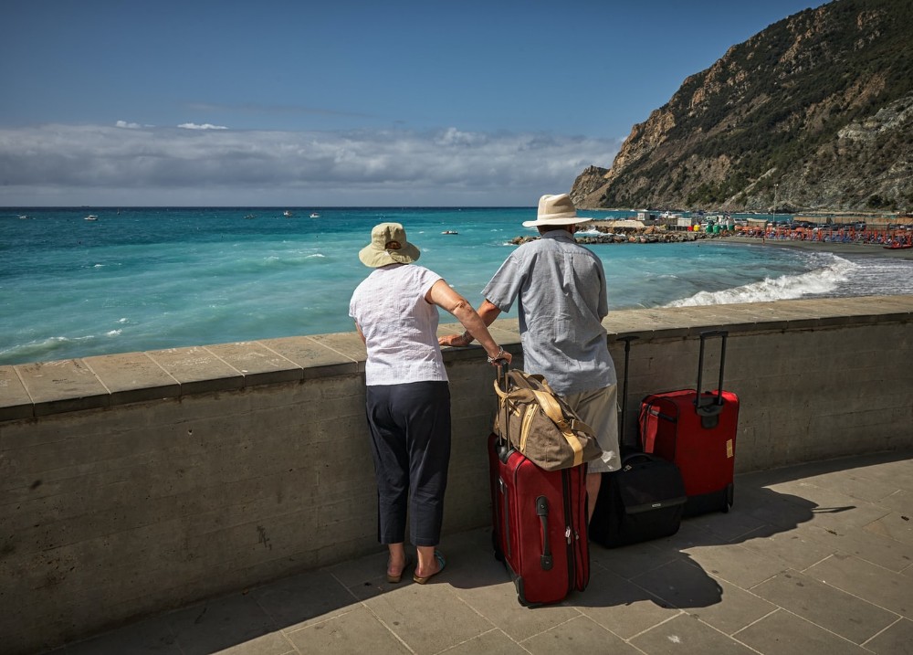 dos turistas españoles de espalda mirando al mar