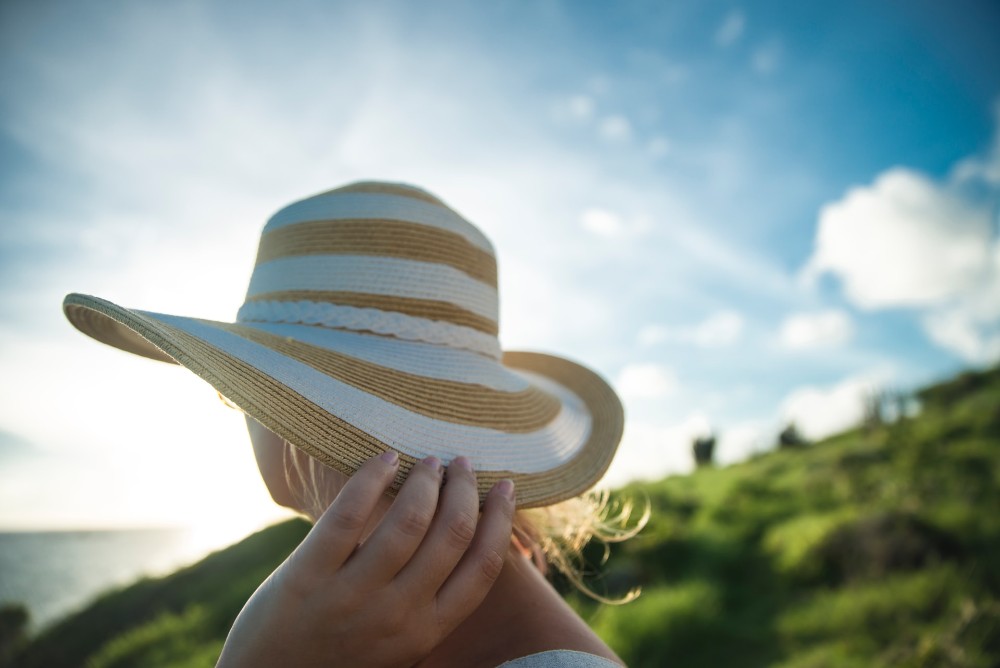 mujer con sombrero en una playa