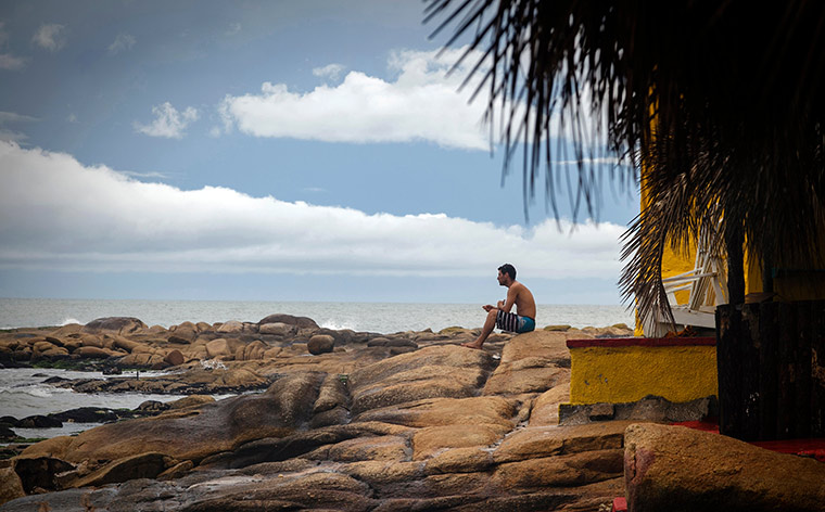 hombre en una playa mirando al mar