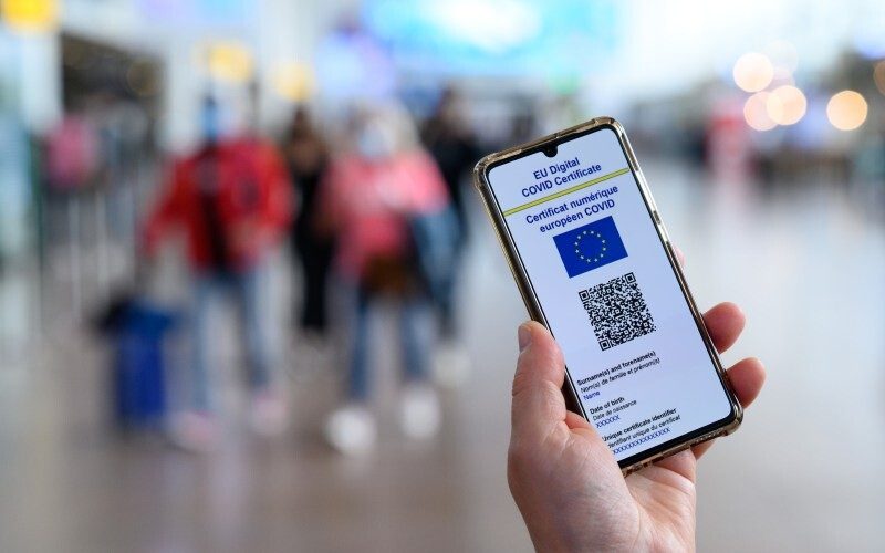 persona sostiene celular con certificado COVID digital